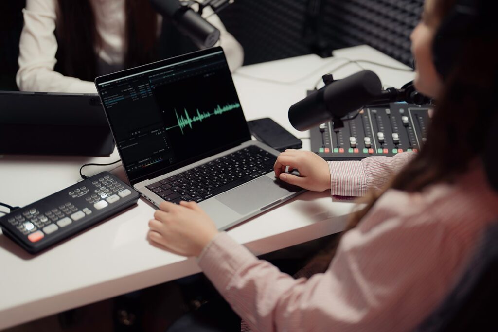 Make Money with Podcasting — Female Host Browsing Netbook and Interviewing Guest During Podcast Recording in Studio Make Money with Podcasting — Female Host Browsing Netbook and Interviewing Guest During Podcast Recording in Studio